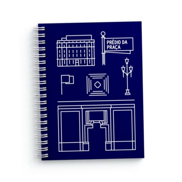 Caderno espiral azul escuro, capa dura e estampa frontal, em branco, de ícones desenhados a partir de elementos retirados da arquitetura do prédio Praça Antônio Prado. Logo B3 centralizado no verso.